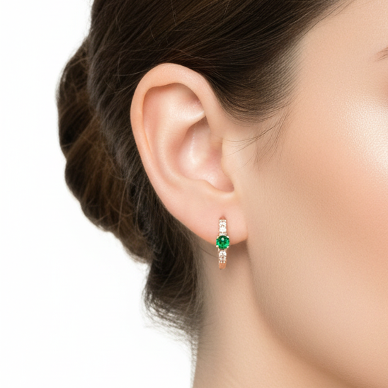 Close-up of a woman wearing emerald green earrings on a white background