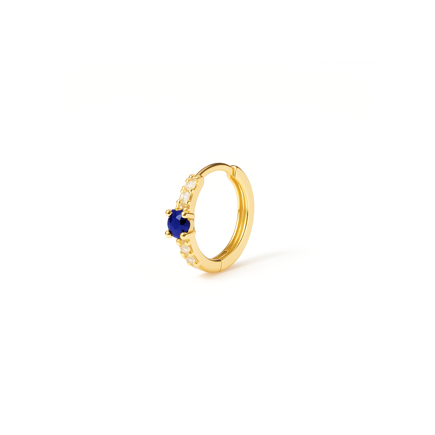 Gold hoop earring with a blue gemstone on a white background