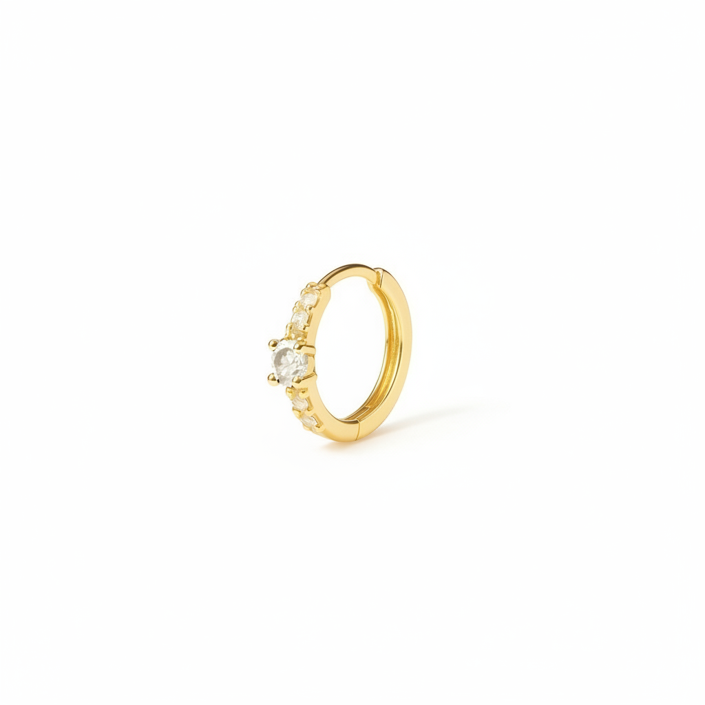 Gold hoop earring with a central gemstone on a white background